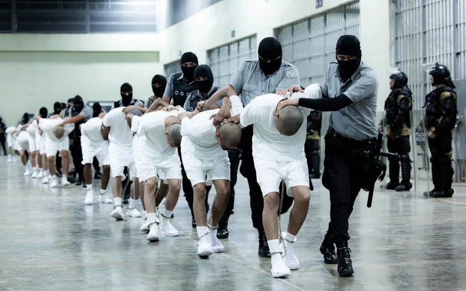 Guards transfer alleged members of Tren de Aragua inside an El Salvadorian prison